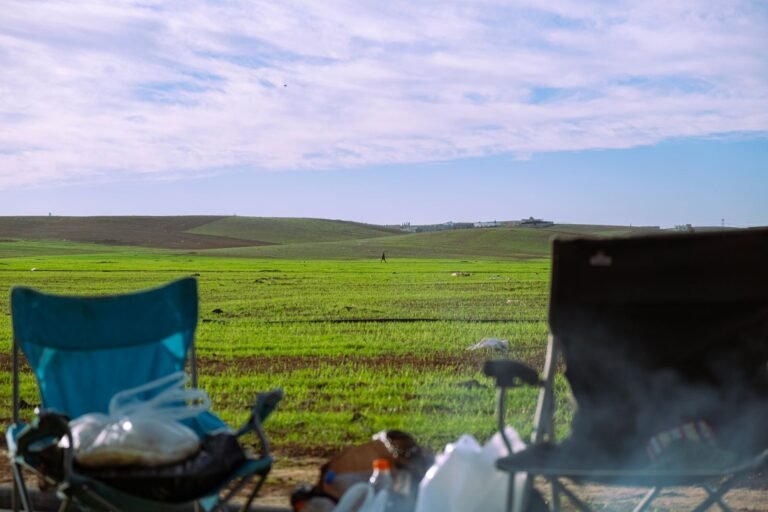 Twee campingstoelen met uitzicht over een groen landschap